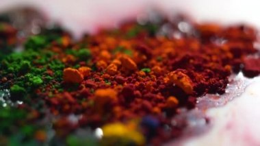 Ezilmiş pastel close-up. Renkli karışık toz boya yüzeyi beyaz sıvı. Parça ve renkli karışık boyalar Holi parçacıkların Close-Up