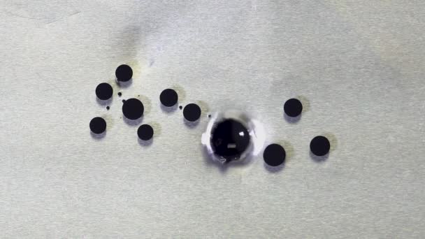 Zwarte ronde drops van olie. Close-up op oppervlak met olie druipend van zwarte inkt. Inkt in olie vervagen niet, houden van de ronde vorm van druppel — Stockvideo