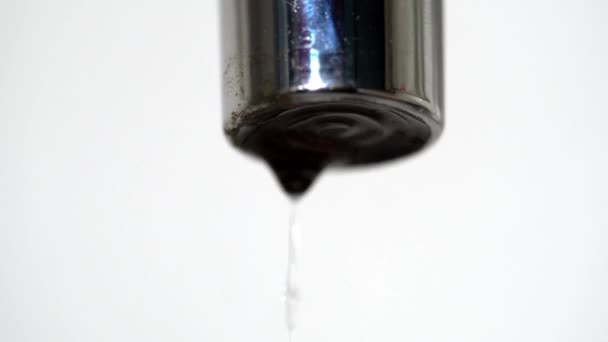 Close-up van water druppelen uit de kraan gat. Water drops stok en druppelen uit slecht gesloten kraan op witte geïsoleerde achtergrond — Stockvideo