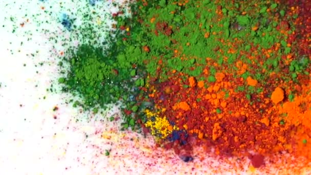 Γκρο πλαν, θρυμματισμένα παστέλ. Χρώμα πολύχρωμα μικτή σκόνη στην επιφάνεια από λευκό υγρό. Holi χρώμα αναμιγνύεται και σκληρύνει από την υγρασία στην επιφάνεια του γάλακτος — Αρχείο Βίντεο