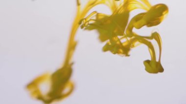 Yakın çekim splash su sarı boya. Güzel dumanlı etkisi dağıtım mürekkep Su damlacıkları. Parlak sarı boya beyaz arka plan üzerinde suda yumuşak dumanlı sıçrama