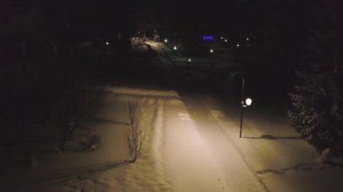 Karla kaplı yollar kış gecesi tarafından sokak ışıkları yanar. Küçük. Karanlık nedeniyle yakın evler yakınındaki kış Park sokak ışıkların Üstten Görünüm