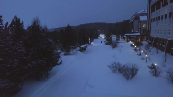 Path of resort in evening in winter. Clip. Top view of resorts dark evening path in cloudy weather. Peace and quiet on park path in snowfall — Stock Video