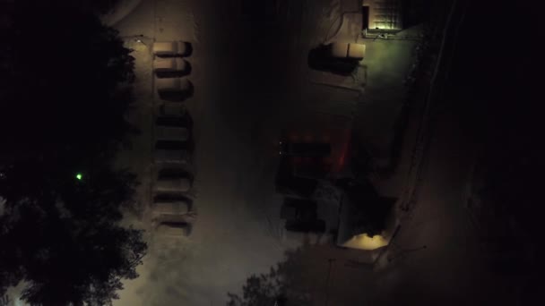 Vista superior do parque de estacionamento à noite no inverno. Clipe. Estacionamento na cidade com carros cobertos de neve e iluminação fraca à noite no inverno — Vídeo de Stock