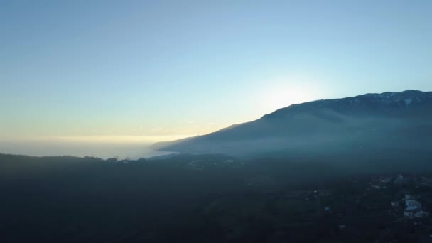 Vista superior del paisaje de montaña con el mar y el cielo despejado amanecer. Le dispararon. Hermoso paisaje pintoresco de montaña con mar y ciudad en la niebla de la mañana — Vídeo de stock