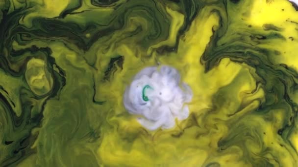 Piękny reakcji na kropelki mydło dodały na żółtych i zielonych atramentów w mleczny substancji. Kolorowe tło cieczy farby ruchomych na białej powierzchni. — Wideo stockowe