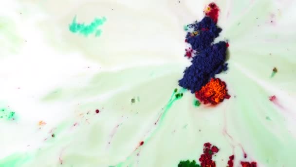 Kolorowe farby suche unoszące się w białe mleko, zasysane jest do lejka. Zielone, czerwone i ciemny niebieski proszek farby na powierzchni cieczy. — Wideo stockowe
