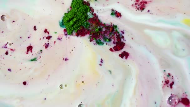 Fantastic, colorful background of dry inks floating on the surface of liquid white substance, top view. Green and purple powder paints move slowly and leave stains. — Stock Video