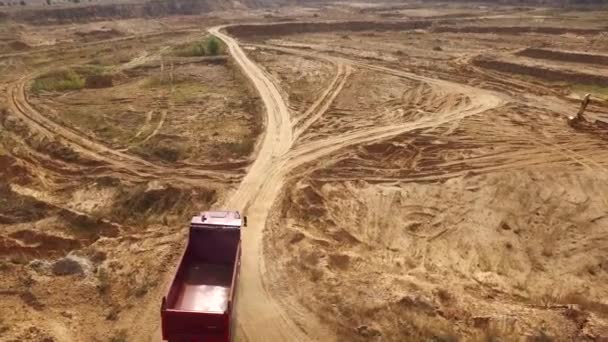 Vista aérea do grande caminhão vermelho vazio que se move em uma trilha arenosa para a areia no deserto ou dunas. Bela vista de cima . — Vídeo de Stock