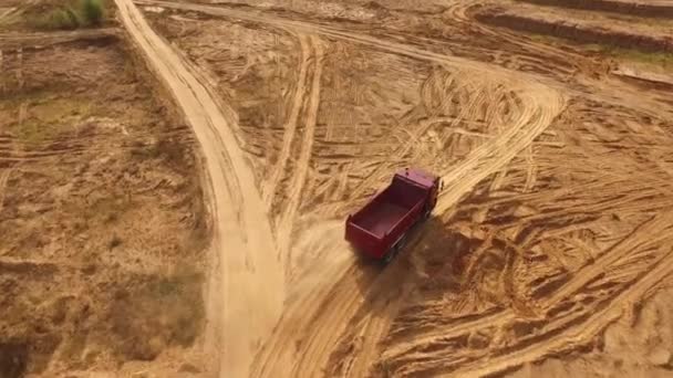 Vista aérea do grande caminhão vermelho vazio que se move em uma trilha arenosa para a areia no deserto ou dunas. Bela vista de cima . — Vídeo de Stock