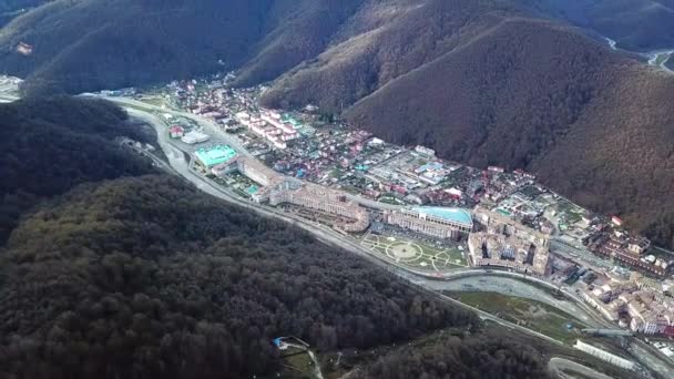 Draufsicht auf die Berglandschaft mit Stadt im Tal. Stadt liegt in einem engen Tal zwischen Bergen und dichtem Wald — Stockvideo