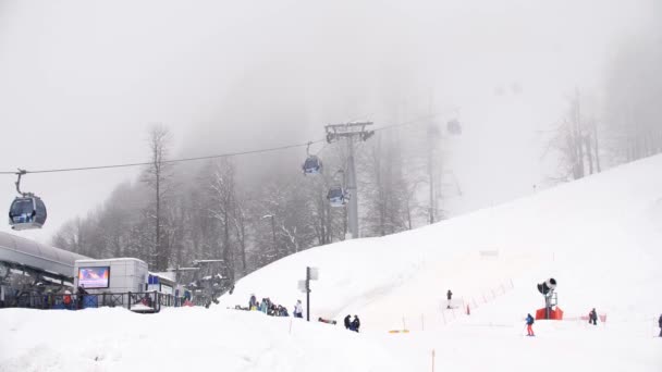 Winterskigebiet mit Skiliften auf den Bergen. Skihang mit Skiliften und Pisten bei nebligem Wetter. Aktivurlaub im Winter — Stockvideo