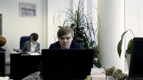 Ung affärsman arbetar med laptop på kontoret. Kontorsarbetare — Stockfoto
