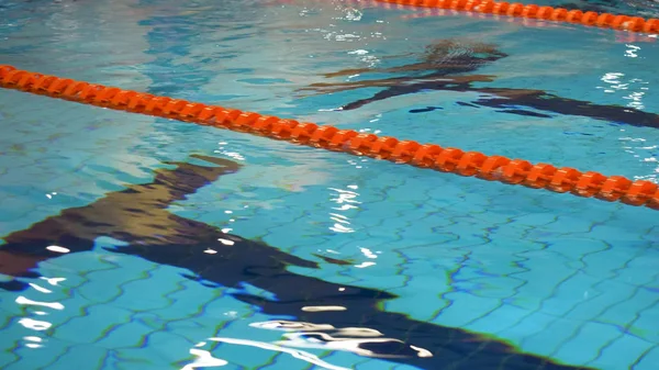 Piscina con agua azul para la natación deportiva con pistas, Primer plano para el agua clara en la piscina con pistas de natación . —  Fotos de Stock