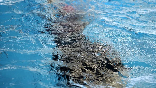 Unschärfe des Lichts, das im blauen Wasser des Pools reflektiert. klares Wasser schwankt, Schwimmbecken Wasser Textur. — Stockfoto