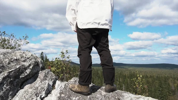 De toerist die zich alleen door het berglandschap van de bos. Achteraanzicht op een rots klimmen en op zoek naar horizon op een zonnige dag, achtergrond van het bos. Op zoek naar de horizon — Stockfoto