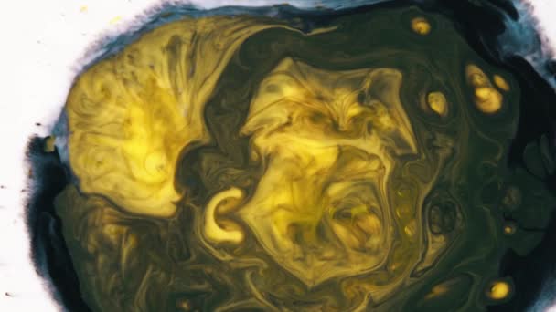 Close-up of yellow and black inks mixing on a white liquid surface. Art concept. — Stock Video