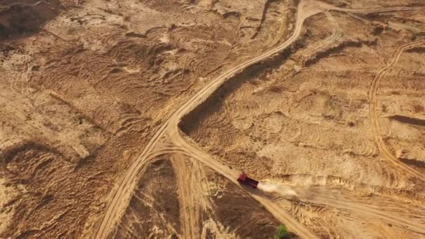 Aerial view of the large red truck moving on a sandy track in desert. Desert trip. — Stock Video