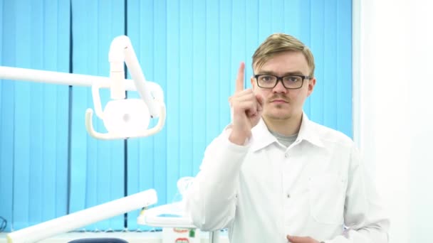 Dentiste masculin sérieux en manteau blanc pointant du doigt vers vous et secouant la tête au cabinet de la clinique dentaire, médecine, stomatologie et concept de soins de santé. Homme dentiste faisant un geste de déni . — Video