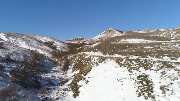 Alpen - Luftaufnahme. Berge unter dem Schnee im Winter. Panorama einer schneebedeckten Gebirgslandschaft mit blauem Himmel — Stockfoto