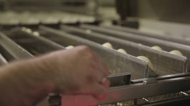 Çörek kızartma yağ fabrikası, kızarmış hamur şekerleme veya tatlı gıda kavramı içinde hazırlama işlemi. Donut ekmek yağ kaynar suda koyarak.