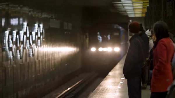 Kommer tåget och personer som väntar på tunnelbanestationen. Tunnelbanestationen transport anländer till tunnelbanestationen med många passagerare väntar på. — Stockfoto