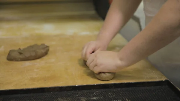 Stäng för baker händer förbereda raw råg för limpan, matkoncept. Kvinna händer att göra en baguette från raw råg degen onwooden styrelsen på bageriet. — Stockfoto