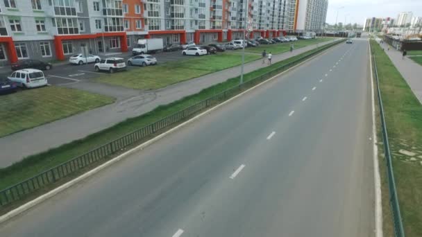 Вид на типичную русскую улицу летом с новыми зданиями, дорогами, автомобилями, пешеходными дорожками и гуляющими людьми. Сцена. Концепция повседневной жизни . — стоковое видео