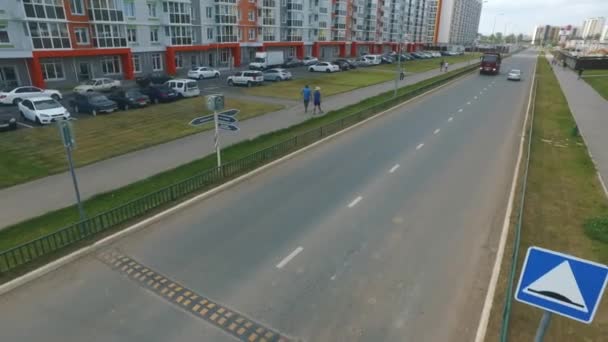 Uitzicht op typische Russisch straat in de zomer met nieuwe gebouwen, weg, auto's, wandelpaden en wandelende mensen. Scène. Dagelijks leven concept. — Stockvideo