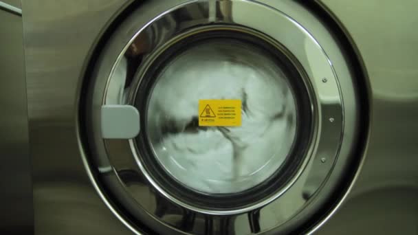 Waschmaschine aus nächster Nähe. Szene. industrielle Waschmaschine funktioniert. Nahaufnahme von Wäschekleidung in industrieller Waschmaschine — Stockvideo