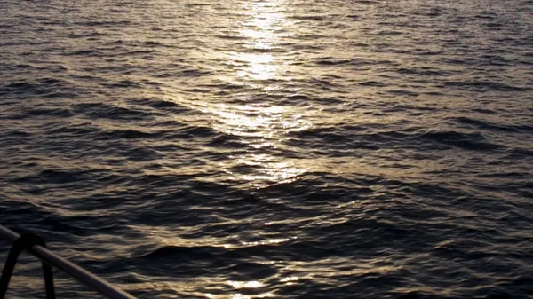 Bellissimo tramonto sul mare e sul ponte del bordo dello yacht. Azioni. Splendido paesaggio marino, increspature nel mare e il sole all'orizzonte . — Foto Stock