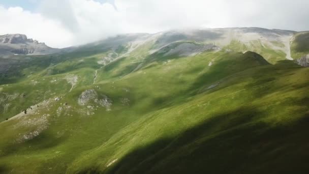 Letecký pohled. Let nad zelené travnaté skalnatého kopce. Létání nad vysokými horami v krásné mraky — Stock video