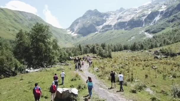 Εναέρια γυρίσματα από το πέταγμα κηφήνας ομάδα πεζοπορία πεζοπορία σε ορεινό μονοπάτι. Ομάδα τουριστών που ταξιδεύουν στην κοιλάδα του βουνού. Περιοδεία πεζοπορία στο βουνό. Ταξιδεύουν με ομαδικό περπάτημα στο μονοπάτι εναέρια θέα στο βουνό — Αρχείο Βίντεο