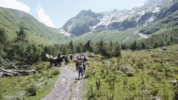 Letecké fotografování z létající dron turistické skupiny chůzi na horské stezce. Turistická skupina cestování v horském údolí. Na pěší túru v horách. Skupina na letecký pohled na horské stezce — Stock video