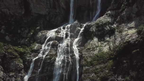 Крупный план бушующих горных водопадов. Вид с воздуха на гигантский водопад, текущий в горах. Красивый пейзаж — стоковое видео
