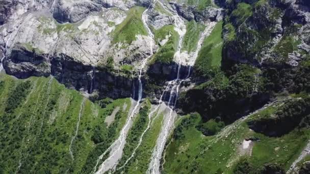 Полет над Алтайскими горами. Потрясающий вид на водопад с воздуха. Водопад впадает в реку — стоковое видео