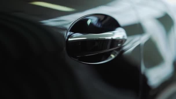 Car door handle close-up. The sunset is reflected in the brand new car. Black car door close-up — Stock Video