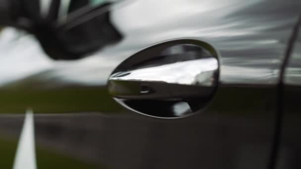 Auto deur handvat close-up. De zonsondergang wordt weerspiegeld in de gloednieuwe auto. Zwarte auto deur close-up — Stockvideo