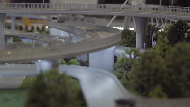Będzie podróżować wzdłuż mostu kolejowego, makiet model w skali. Układ ze stacji naziemnych, zbliżenie — Wideo stockowe