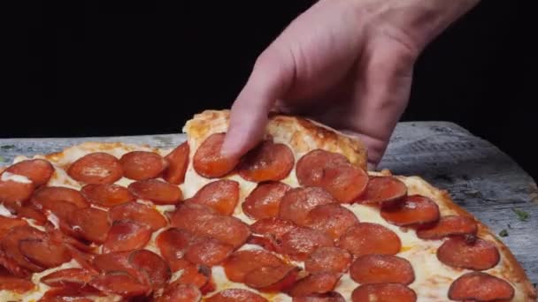 ピザのスライスを取って溶けたチーズ滴下。フレーム。クローズ アップの人の手を取ってスライス ピザ黒背景 — ストック動画