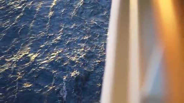 Superficie dell'acqua con piccole onde e il bordo sfocato della barca. Azioni. Riverbero del sole riflesso sulla superficie blu del mare . — Video Stock