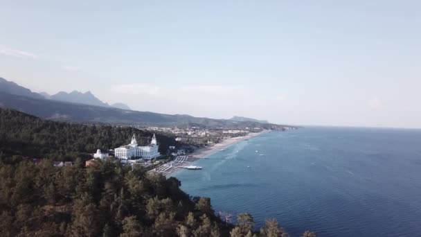 Hotel mavi deniz kıyısında. Video. Beyaz kum, güzel plaj, güzel orman. Okyanus kıyısında tatil. Havadan görünümü — Stok video