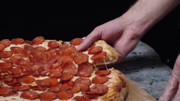 Figyelembe véve a szelet pizza, csuromvizesen sajt olvad. Keret. Közelkép a emberek kezében véve szelet Pizza fekete háttér — Stock videók