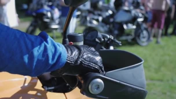남자는 오토바이 핸들을 확인합니다. 클립입니다. A 망 손 회전 가스 페달. 손 보호 장갑 입고의 근접 촬영 — 비디오