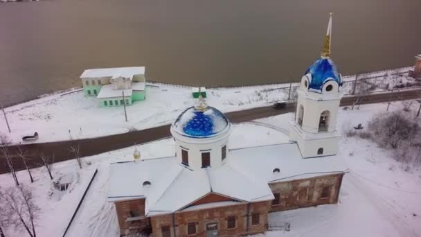 Vista aérea de la Iglesia en Rusia. Clip. Iglesia de la pequeña ciudad durante el invierno nevado en una pequeña ciudad — Vídeos de Stock