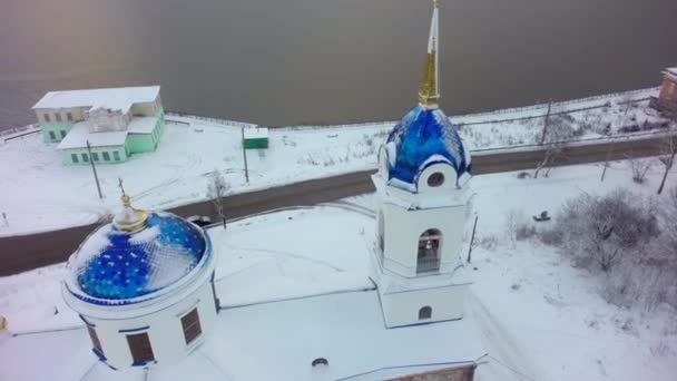 Vista aérea de la Iglesia en Rusia. Clip. Iglesia de la pequeña ciudad durante el invierno nevado en una pequeña ciudad — Vídeo de stock