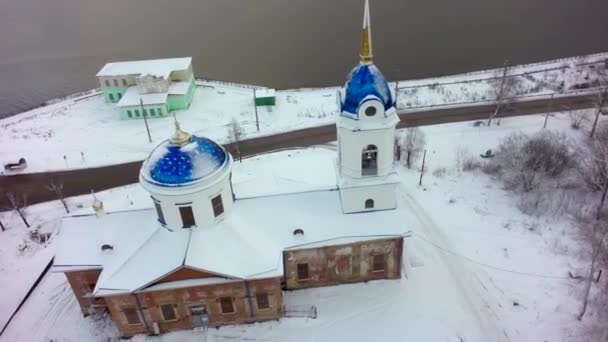 Vista aérea de la Iglesia en Rusia. Clip. Iglesia de la pequeña ciudad durante el invierno nevado en una pequeña ciudad — Vídeos de Stock