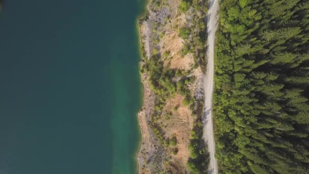 空中ドローンを驚くべき湖沿いの道を撮影しました。クリップ。池と山の道路平面図します。 — ストック動画