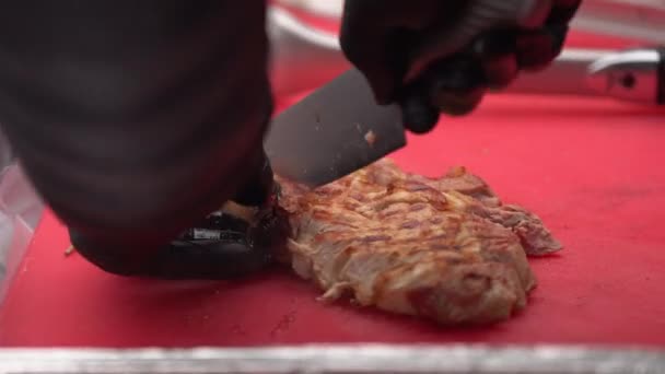 Chef em luvas pretas corta carne suculenta bife na tábua de madeira com a faca, close-up. Bifes de carne deliciosos, suculentos e cozidos na hora cozinham cortes na tábua de corte. Suco dos bifes permanece no — Vídeo de Stock