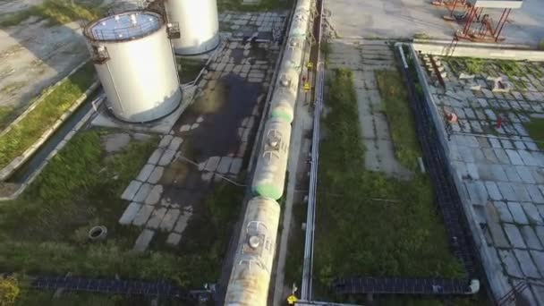 Tren de mercancías en el patio de maniobras Vista aérea. Acciones. Tren de carga con petróleo. Volar por encima de la estación de ferrocarril industrial con tren de carga y contenedores de carga — Vídeo de stock